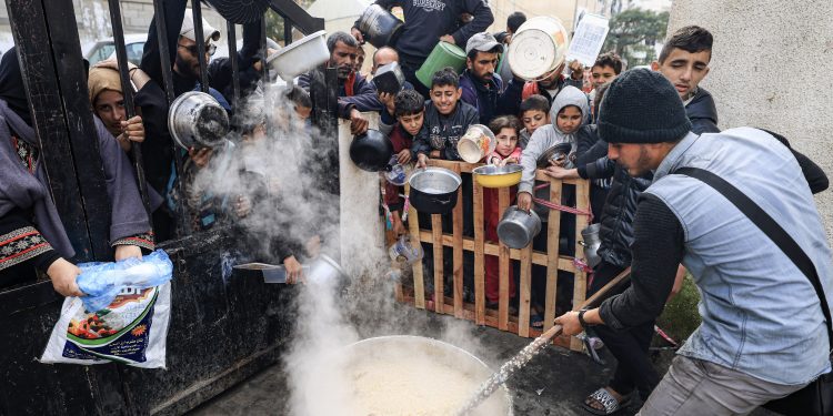 فلسطينيون ينتظرون الطعام عند نقطة تبرع في مخيم للاجئين في رفح جنوب قطاع غزة ديسمبر 2023 (ا ف ب)