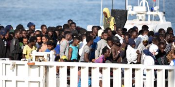 رجال ينتظرون النزول من سفينة خفر السواحل الإيطالية "ديسيوتي" بعد عملية إنقاذ المهاجرين واللاجئين في البحر في 13 يونيو 2018 في ميناء كاتانيا، صقلية. (أ ف ب).
