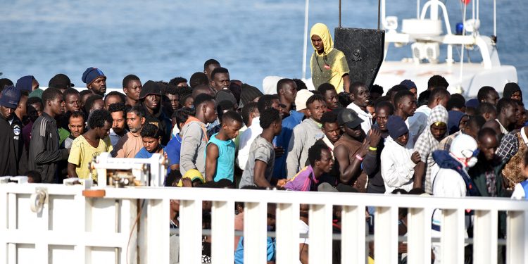 رجال ينتظرون النزول من سفينة خفر السواحل الإيطالية "ديسيوتي" بعد عملية إنقاذ المهاجرين واللاجئين في البحر في 13 يونيو 2018 في ميناء كاتانيا، صقلية. (أ ف ب).