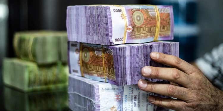 تاجر يقوم بترتيب الأوراق النقدية في سوق بمدينة القامشلي شمال شرقي سوريا في 10 سبتمبر 2019. (أ ف ب).