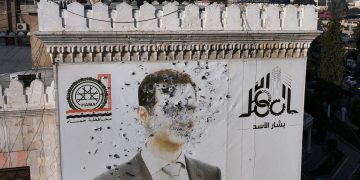 رصاص أطلقه مسلحون معارضون على رسم للرئيس السوري بشار على مبنى بلدية حماة، 6 ديسمبر 2024 (ا ف ب)
